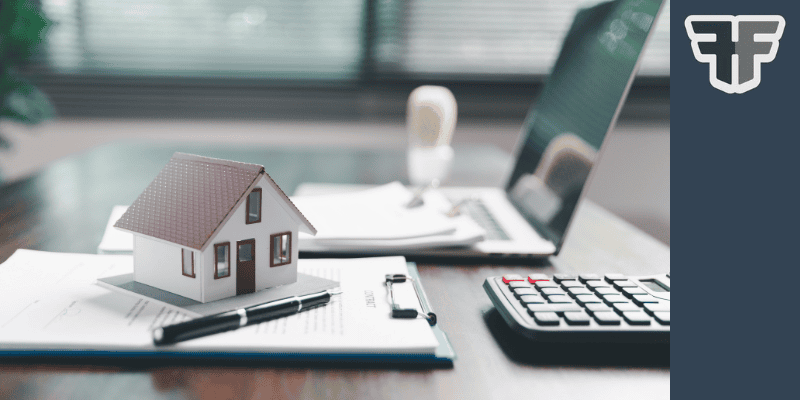 Image of a desk with laptop and documentation with a house indicating a mortgage review with Financial Fortress